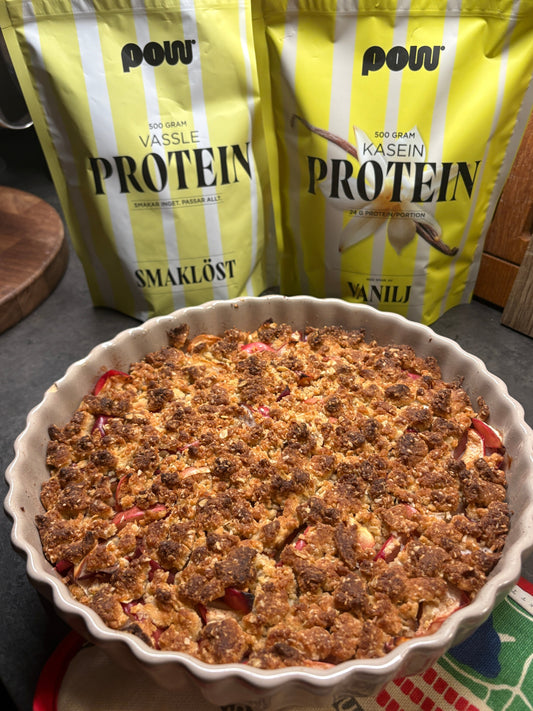 Gyllenbrun äppelsmulpaj i pajform, med POW proteinpulver i bakgrunden