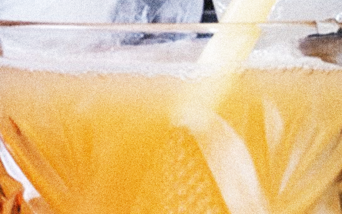 Biffprotein från POW – klar kollagen mango & passion i glas mot ljus bakgrund