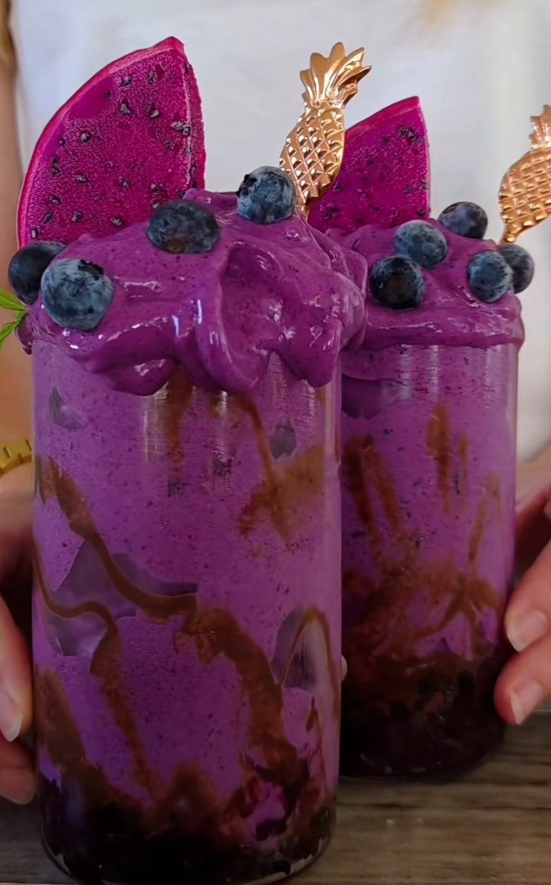 Två glas lila blåbärsnicecream med chokladsås, färska blåbär och rosa pitaya – proteinrik nicecream med POW kaseinprotein vanilj