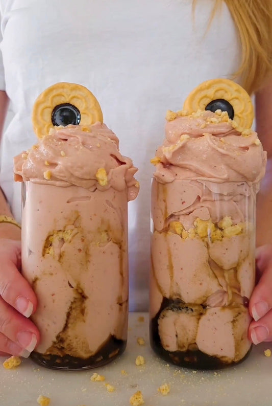 Två glas med rosa hallon- och lakritsnicecream från POW, toppade med smulade kex.