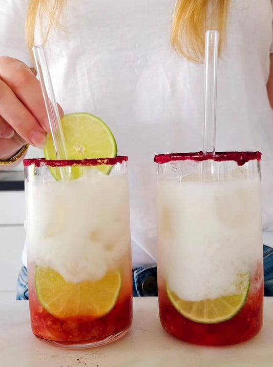 Rosa jordgubbs- och hibiskusrefresher med POW kaseinprotein vanilj, toppad med lemon-lime läsk och en limeskiva