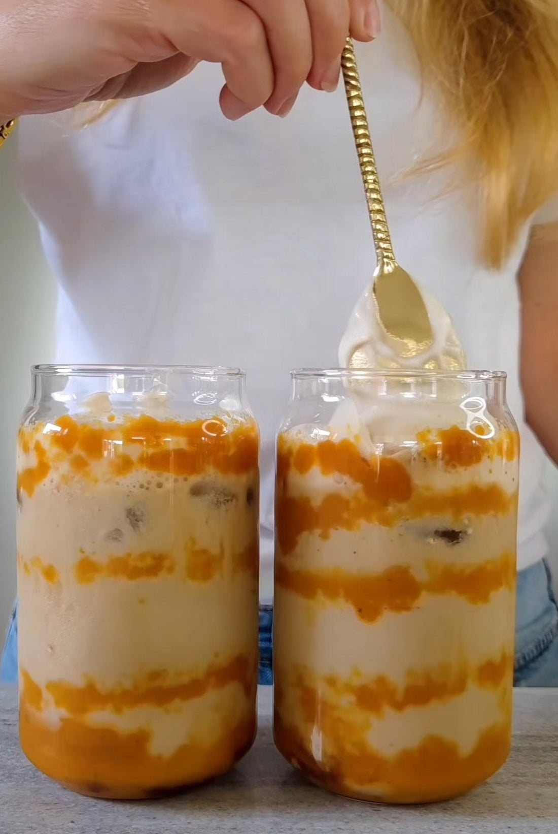 Proteinrikt pumpkin spice-iskaffe med pumpapuré och fluffigt jordnötssmörskum av POW-protein i två glas