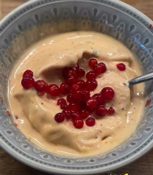 Rosa nice cream med mango, jordgubb och passionsfrukt toppad med röda vinbär i en skål