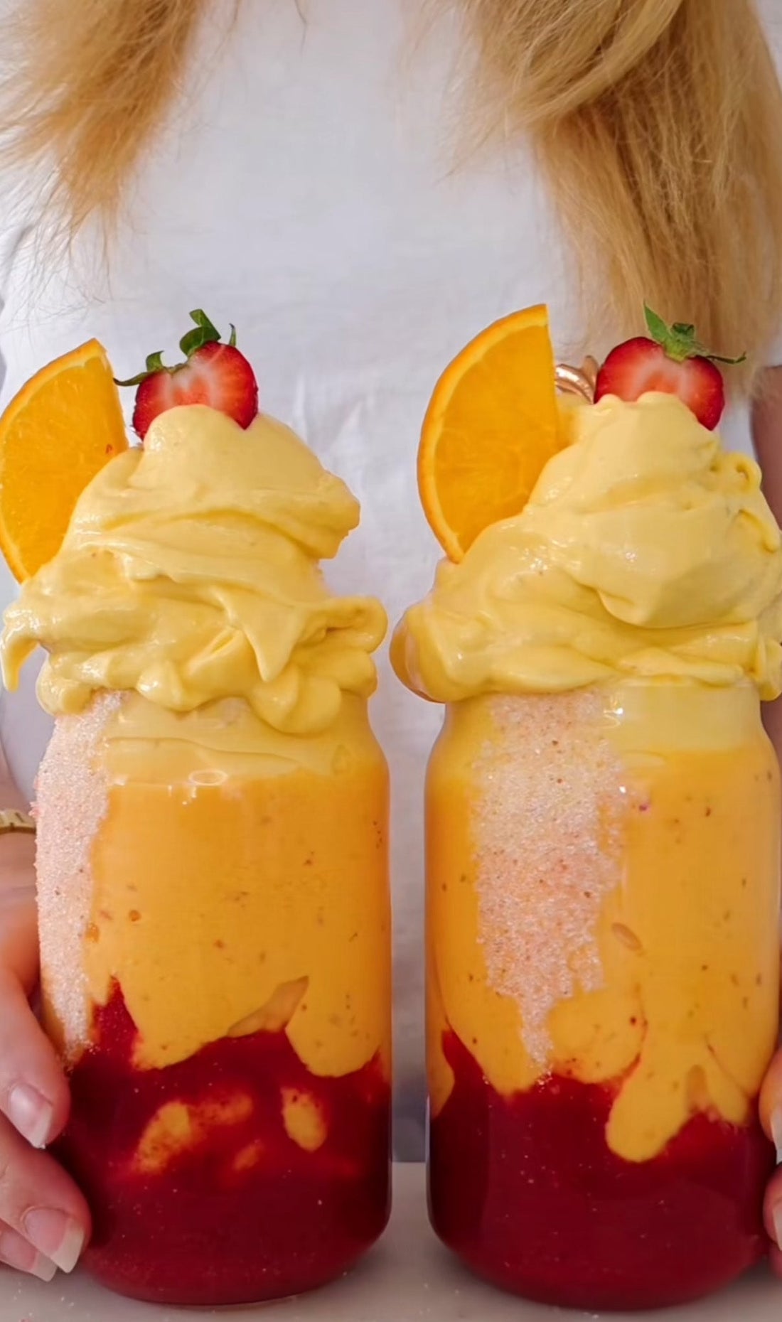 Soluppgångsfärgad nicecream med fryst mango, körsbär, granatäpple och POW clear whey citron protein, toppad med jordgubbar och apelsinskivor