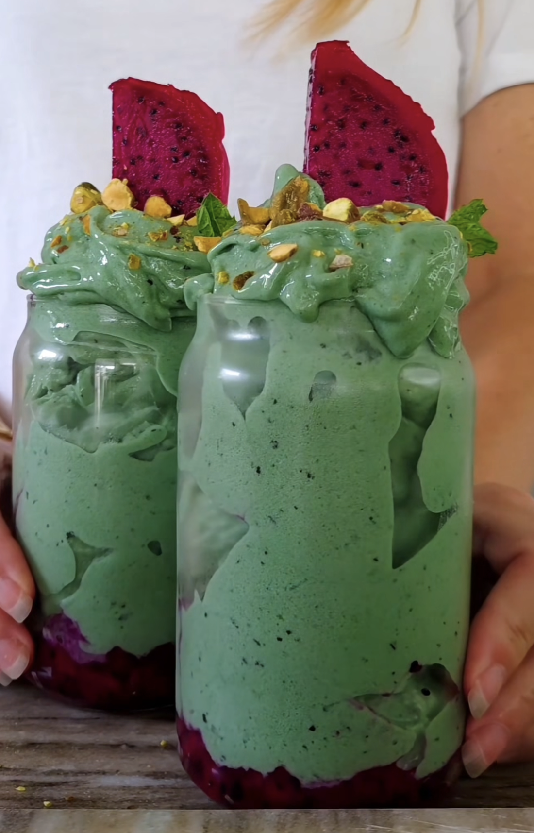 Mango- och passionsfruktsmoothie med grön spirulina och POW kaseinprotein, toppad med pistagenötter och rosa drakfrukt