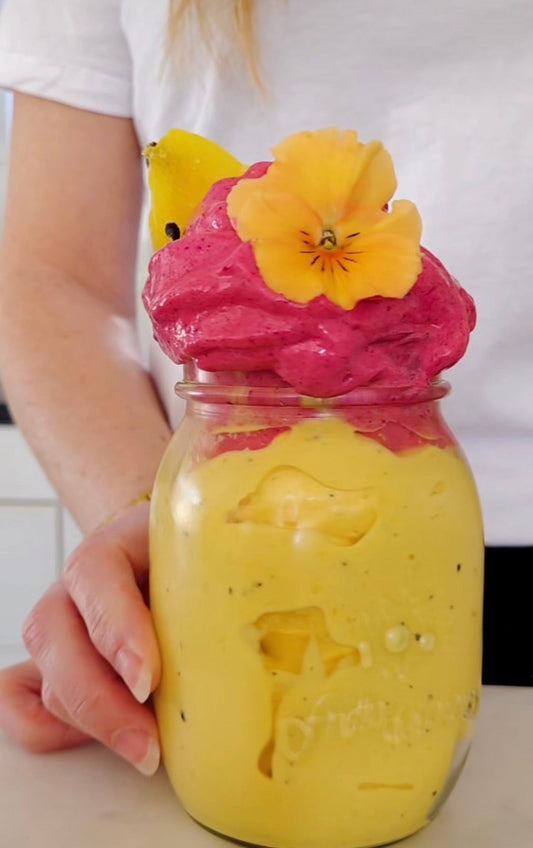 Tropical nicecream med banan, mango, passionsfrukt och POW kaseinprotein vanilj toppat med pink pitaya och ätliga blommor